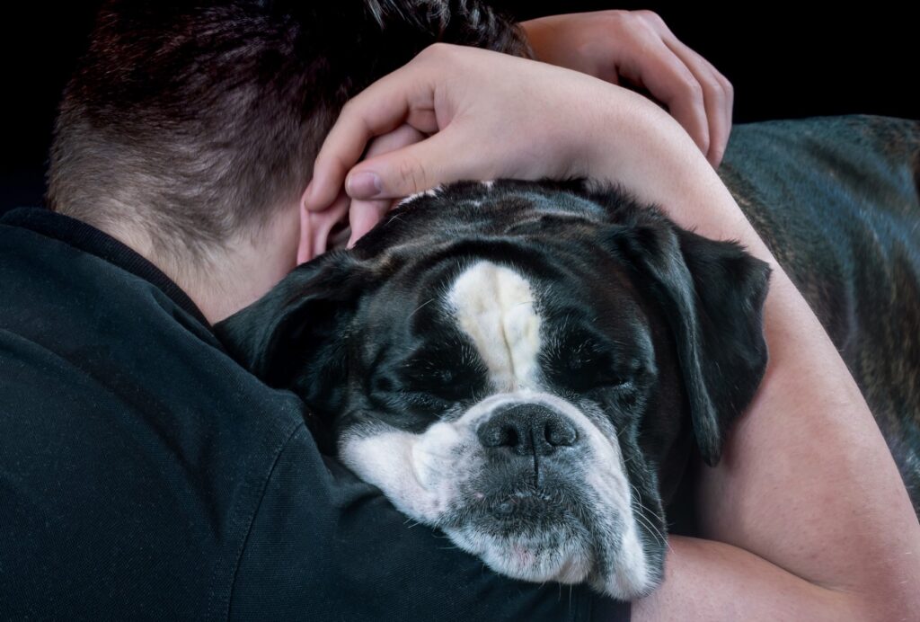 man hugging his dog