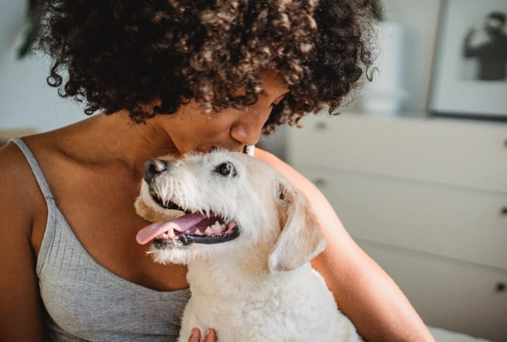 woman hugs and kisses her dog